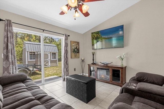 living room with ceiling fan, vaulted ceiling, and light tile patterned floors