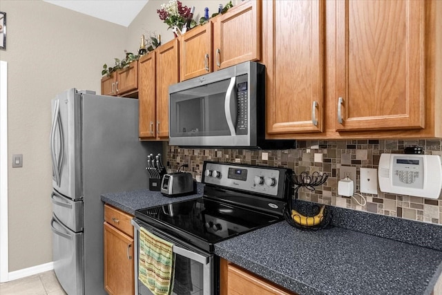 kitchen featuring appliances with stainless steel finishes, light tile patterned floors, and tasteful backsplash