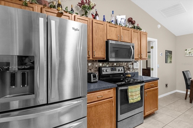 kitchen with lofted ceiling, stainless steel appliances, light tile patterned flooring, and decorative backsplash