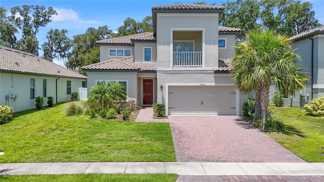 mediterranean / spanish home with a garage, a balcony, and a front lawn