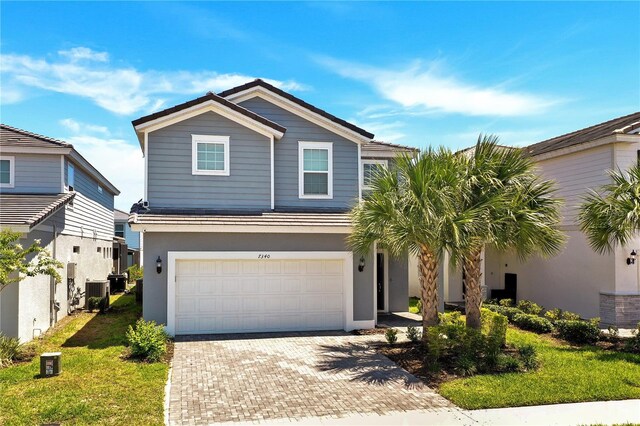 view of front of home with central AC and a garage