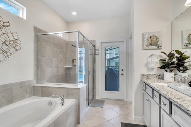 bathroom featuring vanity with extensive cabinet space, separate shower and tub, and tile floors