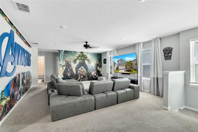 living room featuring carpet, ceiling fan, and a textured ceiling