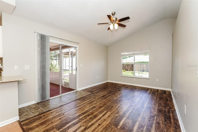 empty room with dark hardwood / wood-style floors, vaulted ceiling, and ceiling fan