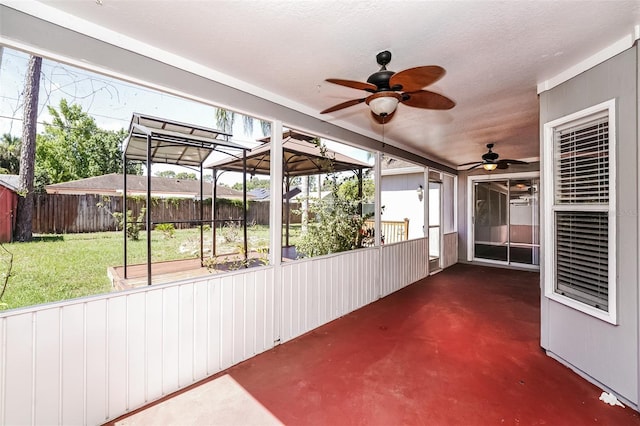 unfurnished sunroom featuring ceiling fan