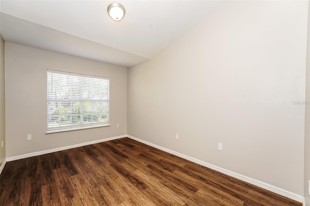 unfurnished room with lofted ceiling and dark hardwood / wood-style floors