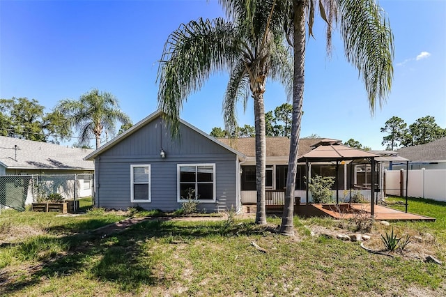 back of property featuring a gazebo and a lawn