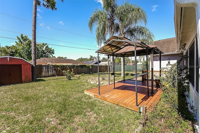 view of yard with a gazebo, a storage shed, and a wooden deck