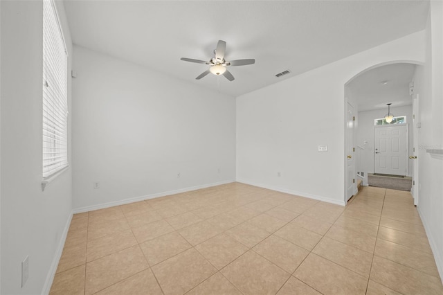 spare room with ceiling fan and light tile floors