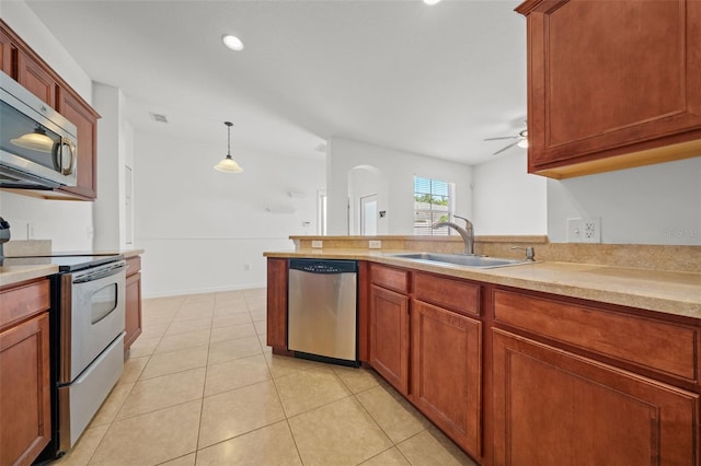 kitchen with decorative light fixtures, ceiling fan, appliances with stainless steel finishes, sink, and light tile floors