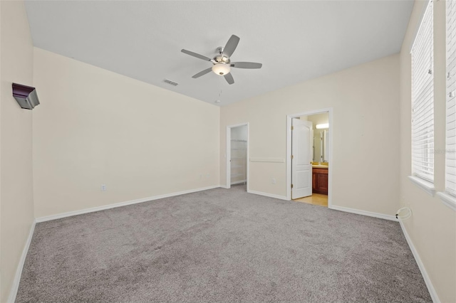 unfurnished bedroom featuring a closet, ceiling fan, carpet floors, and ensuite bath