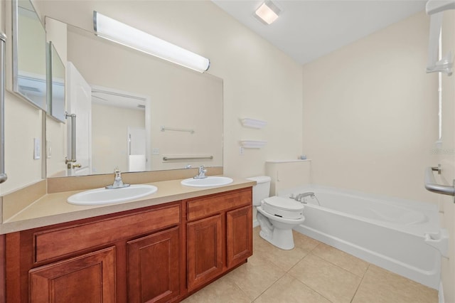 bathroom featuring tile floors, a bathing tub, double vanity, and toilet