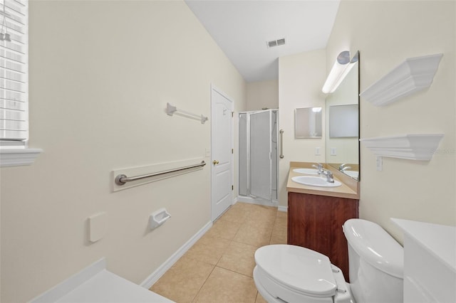 bathroom featuring vanity, toilet, tile floors, and a shower with door