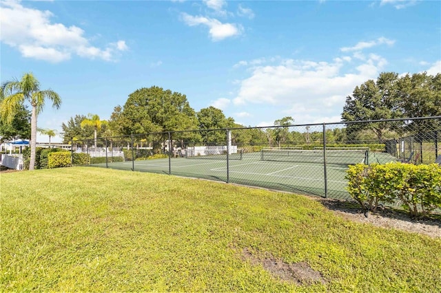 view of sport court with a lawn