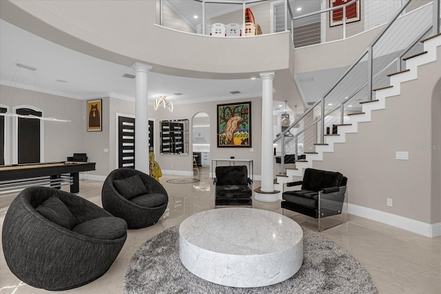 living room featuring ornamental molding, decorative columns, and a high ceiling