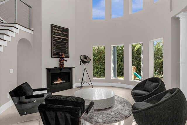 living room with decorative columns and a high ceiling