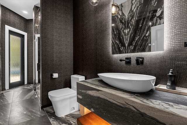 bathroom with sink, a wealth of natural light, and toilet