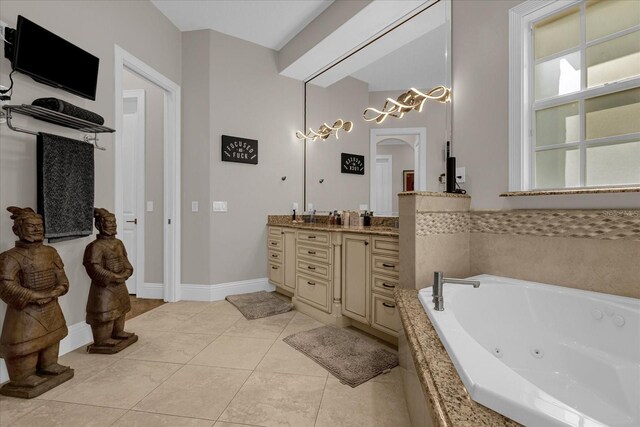 bathroom featuring tile patterned floors, vanity, and tiled bath