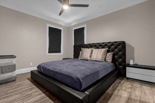 bedroom with ceiling fan, ornamental molding, and wood-type flooring