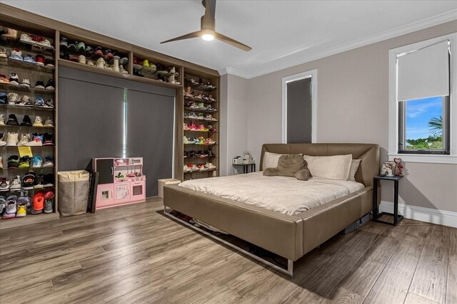 bedroom with ceiling fan, ornamental molding, and wood-type flooring