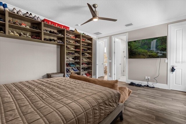 bedroom featuring crown molding, hardwood / wood-style floors, a textured ceiling, and ceiling fan