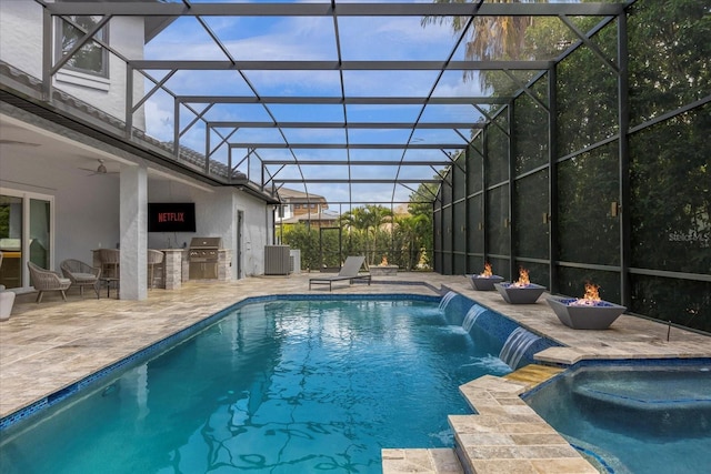 view of pool with a patio, glass enclosure, central AC unit, area for grilling, and pool water feature