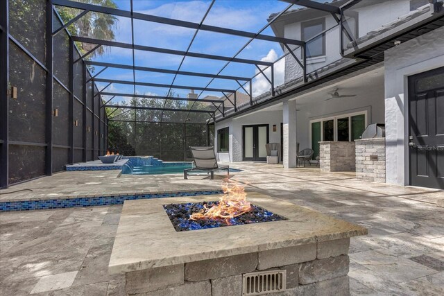 view of patio featuring a lanai, pool water feature, ceiling fan, and an outdoor kitchen