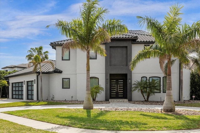 mediterranean / spanish house featuring a garage and a front lawn