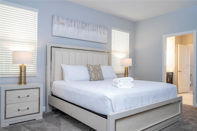 bedroom featuring connected bathroom and light carpet