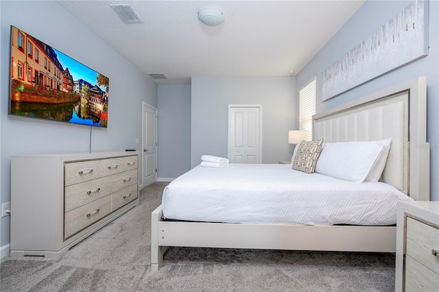 carpeted bedroom with a closet and a textured ceiling