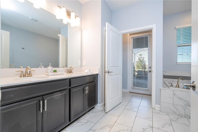 bathroom with tiled tub and vanity