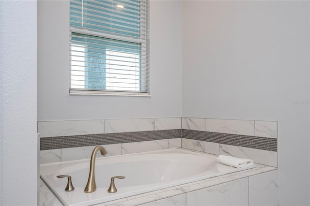 bathroom featuring tiled tub