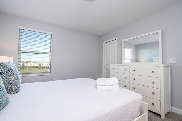 bedroom featuring a closet, a textured ceiling, and carpet