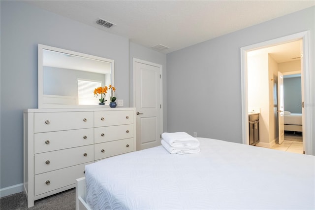 bedroom featuring ensuite bathroom and carpet floors