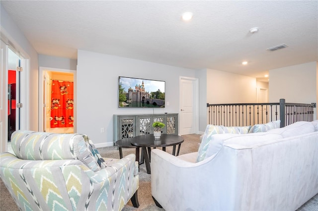 carpeted living room featuring a textured ceiling