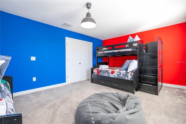 carpeted bedroom featuring a closet and a textured ceiling