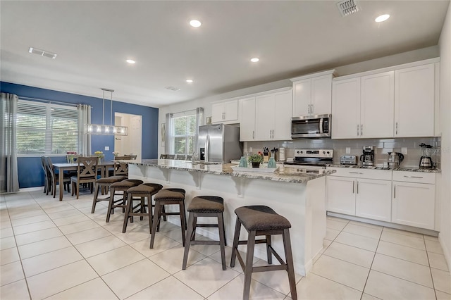 kitchen featuring light tile patterned floors, visible vents, tasteful backsplash, and appliances with stainless steel finishes