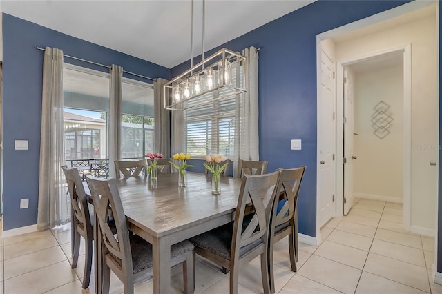 tiled dining space featuring an inviting chandelier