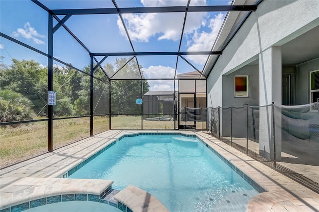 view of pool featuring a lanai, a pool with connected hot tub, and a patio