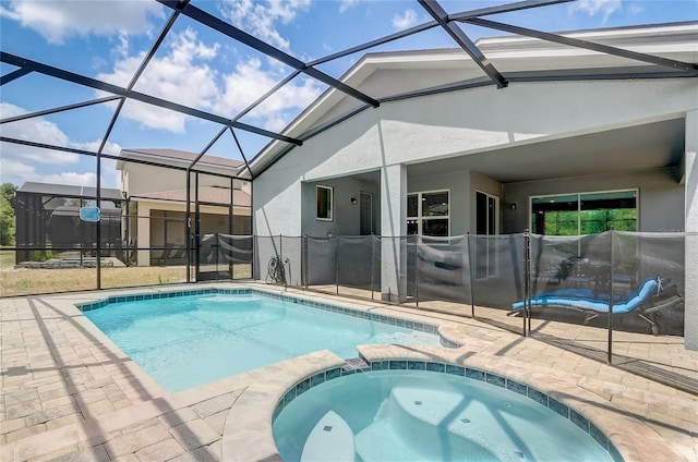 view of swimming pool featuring glass enclosure, a patio area, and an in ground hot tub