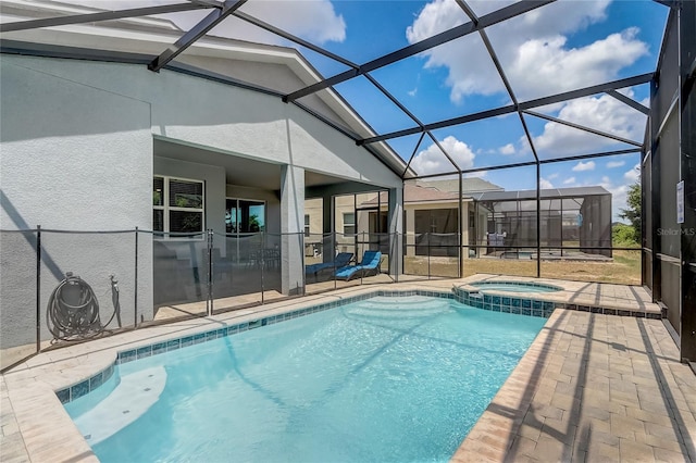 view of pool with a lanai, a pool with connected hot tub, and a patio