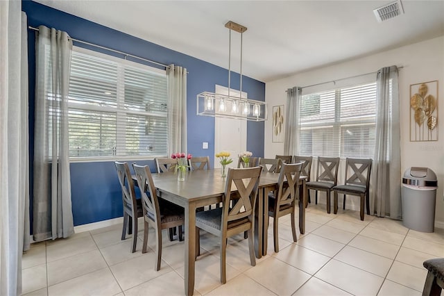 dining room with light tile patterned floors, visible vents, baseboards, and an inviting chandelier