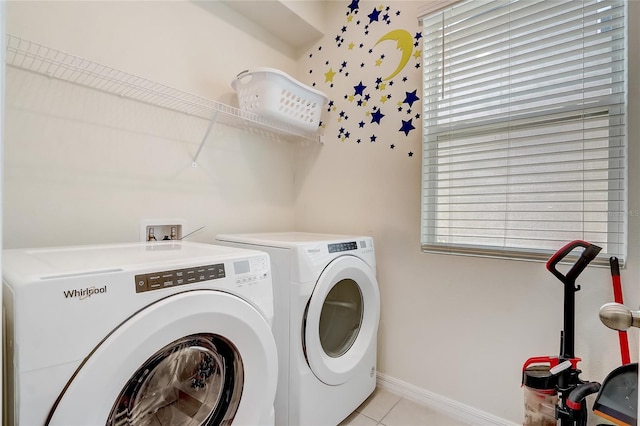 laundry room with washer and clothes dryer, a healthy amount of sunlight, and light tile patterned floors