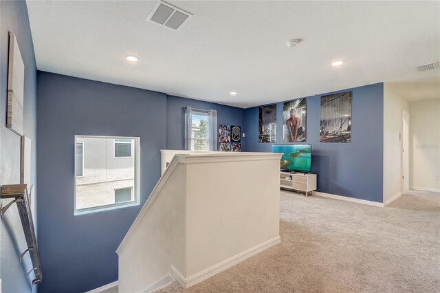 hallway featuring light colored carpet