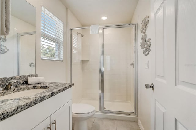 bathroom with tile patterned flooring, vanity, toilet, and an enclosed shower