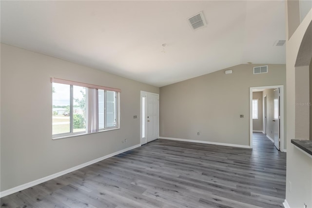 spare room with dark hardwood / wood-style flooring and lofted ceiling