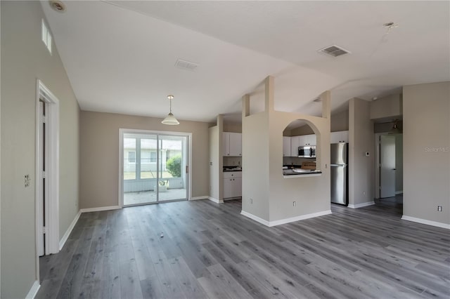 unfurnished living room featuring light hardwood / wood-style flooring and lofted ceiling