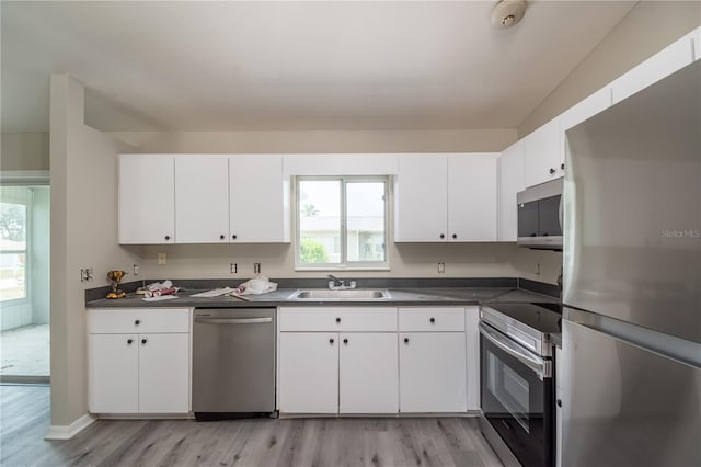 kitchen featuring white cabinets, sink, light wood-type flooring, and stainless steel appliances