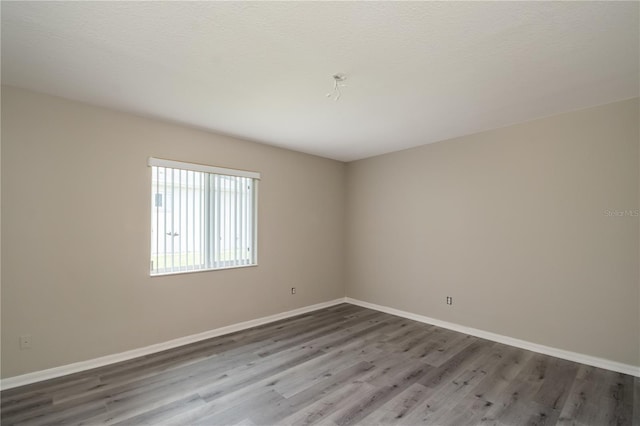 unfurnished room with hardwood / wood-style flooring and a textured ceiling