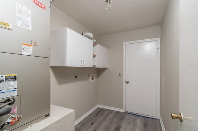 washroom with cabinets, hookup for a washing machine, light wood-type flooring, heating unit, and electric dryer hookup